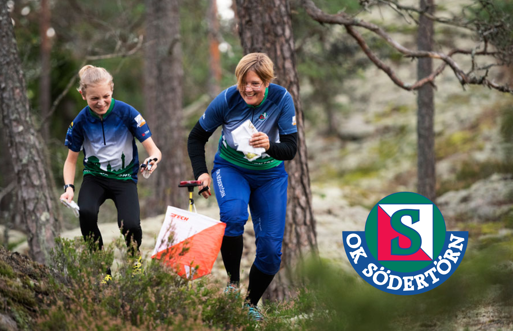 En ung kille och en vuxen kvinna springer orientering i skogen